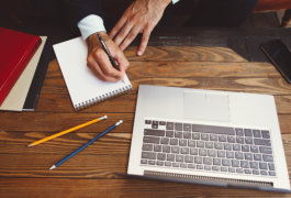 man writing on his notepad